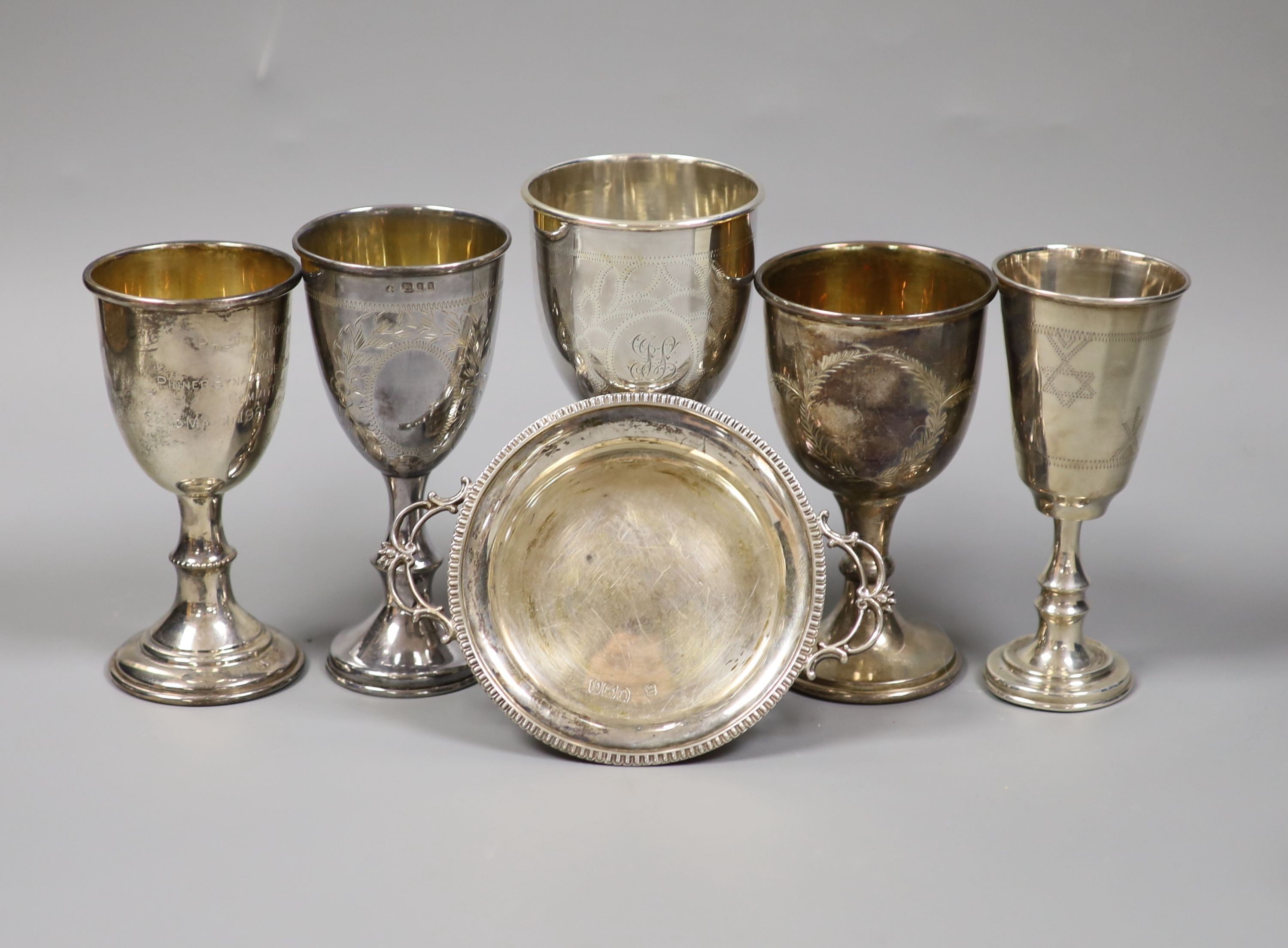 A silver kiddush cup, four other silver goblets and a late Victorian silver two handled dish, 13oz.